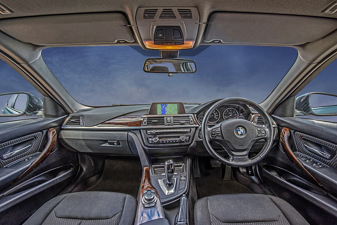 A view across a car passenger compartment showing seats, dashboard and vents.